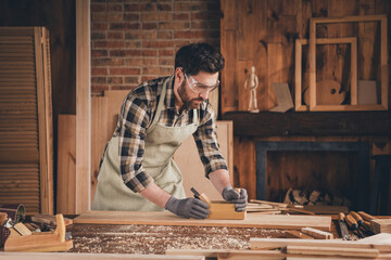Photo of safe guy master at home manufacture in apron and glasses doing his job professionally...