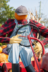 pumpkin head farmer on a tractor with pumpkins