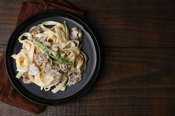 Delicious pasta with mushrooms on wooden table, top view. Space for text