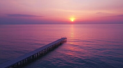 Obraz premium Serene Sunset Over Tranquil Ocean with Pier Silhouetted Against Colorful Sky, Capturing the Essence of Peace and Natural Beauty in a Coastal Landscape