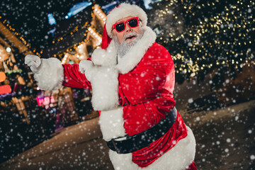 Portrait of funky granddad santa claus have fun dancing newyear midnight garland decor city center outside