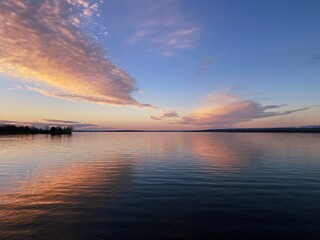 A breathtaking sunset over the Ottawa River, Canada, with soft pastel colors reflected in the calm...
