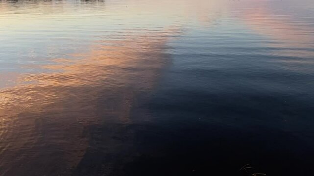 A breathtaking sunset over the Ottawa River, Canada, with soft pastel colors reflected in the calm water. The horizon and scattered clouds create a serene and tranquil atmosphere