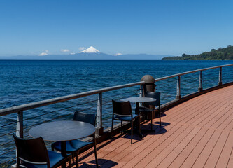 A picturesque view from the terrace of Teatro del Lago in Frutillar, Chile, overlooking the serene Llanquihue Lake and the distant Andes mountains.