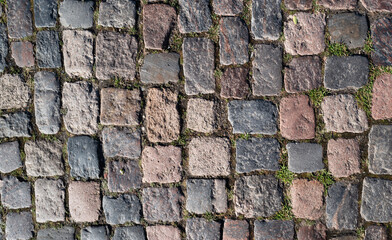 Background of bricks road. Background with bricks road. Stone cladding pavement. Brick surface background. Rough brick road. Stone pavement texture.