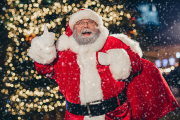 Photo of jolly cheerful bearded man grandpa thumb up enjoying walking city center bright lights...