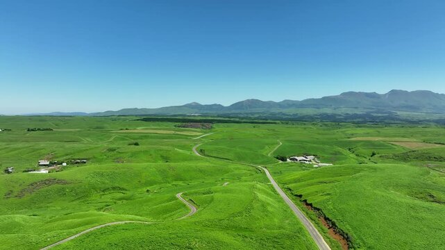 空撮、風景、景色、道路、牧場、高原、自然、環境、俯瞰、絶景、ドローン、大地、大自然、草原、丘陵、新緑、グリーン、エコロジー、エコシステム、地球環境、環境保護、気候変動、サステナブル、SDGs、持続可能な開発目標、サステナビリティ、ESG投資、CSR、高地、山地、ハイアングル、展望、パノラマ、鳥瞰図、上から見た、見下ろす、地平線、景観、迫力、遠景、pov、谷間、台地、牧草地、春、夏、日本、旅行、観光