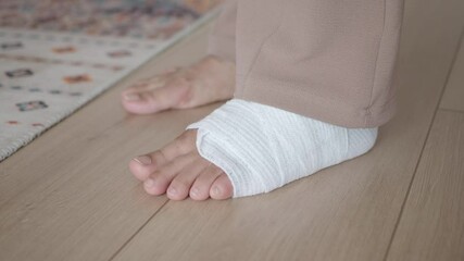 An Injured Foot Carefully Wrapped in a Medical Bandage Resting on a Wooden Floor Surface