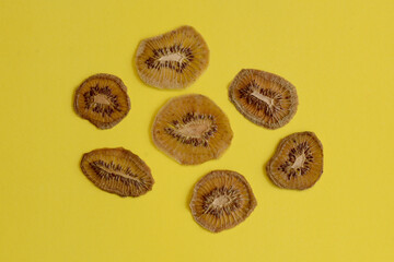 Dehydrated kiwi, top view of sliced ​​sweet green dried kiwi placed on a yellow colr surface