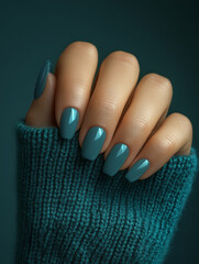 Elegant hand with teal nail polish, showcasing cozy sweater. vibrant color contrasts beautifully with soft texture, creating warm and inviting atmosphere
