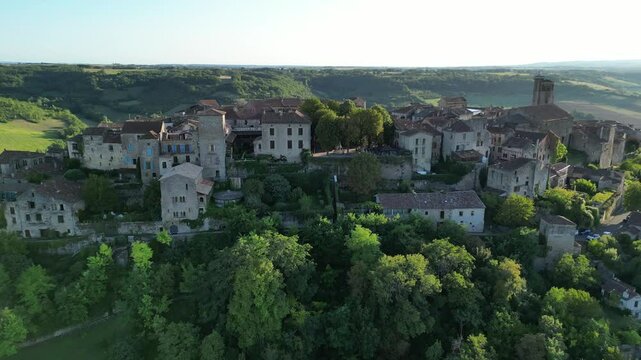 Drone aerial view in France countryside small old medieval brick town zooming out on a sunny day in Cordes Sur Ciel
