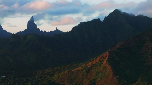 Golden hour sunset Cooks Opunohu Bay Moorea island French Polynesia aerial drone clouds covering Mount Mauaroa Tohivea Rotui clouds lagoon coral reef waves Pacific Ocean circle right parallax