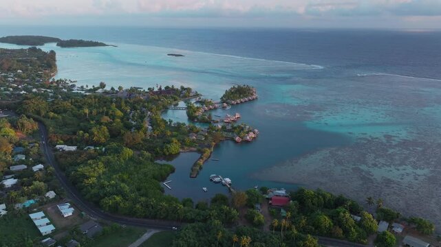 Bungalow villas car morning islands Cooks Opunohu Bay Moorea French Polynesia aerial drone Mount Mauaroa Tohivea Rotui clouds lagoon coral reef vibrant green blue Pacific Ocean forward pan up motion