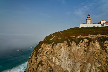 light house at the rugged rocky coastline at cabo da roca.