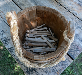 Top view of traditional wooden clothespins in a wooden bucket