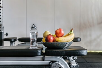Fresh Fruit and Water Bottle on Gym Bench: Healthy Lifestyle and Hydration Promotion

