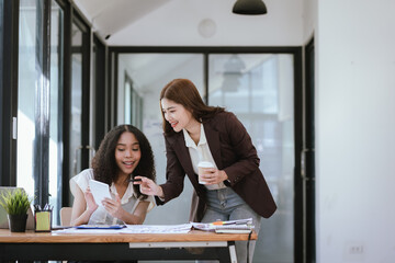 Two business women analyzing income charts and graphs with modern laptop computer. Business...