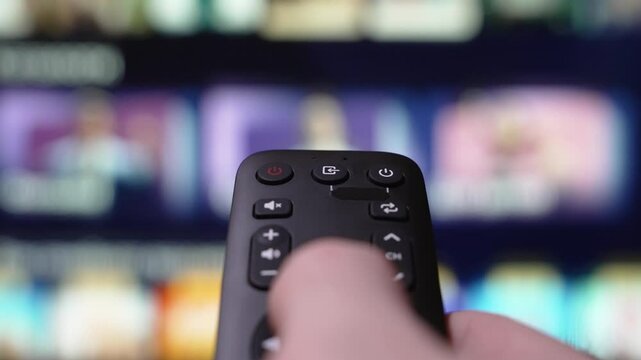 Hand Holding a Remote Control Browses Various Streaming Services On a Large Screen. Person Browsing Streaming Services Using Remote Control and Turn Off smart TV. Internet TV