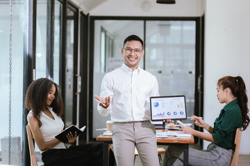 A team of professionals gathers in a modern office for a corporate meeting to analyze financial...