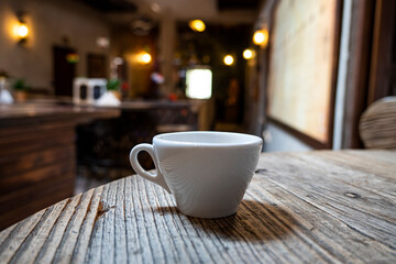 Hot coffee in white cup on table in restaurant and cafe. Hot Coffee Cup on Wood Table in blurred Coffee Shop background.