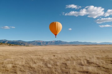 Naklejka premium Balloon air drifting over a desert landscape, with the golden dunes stretching endlessly below