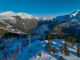 High voltage line over the mountain. With fantastic nature in the background. Snow covered...