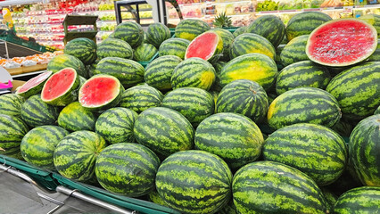 Watermelon Abundance: A vibrant display of fresh watermelons, their green rinds and juicy red...