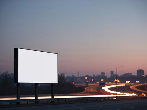 Blank billboard on the highway during the twilight with city background.