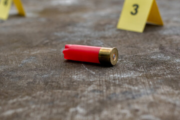 Shotgun bullet shell and blurred number 3 on yellow paper on dirty cement floor, concept for...