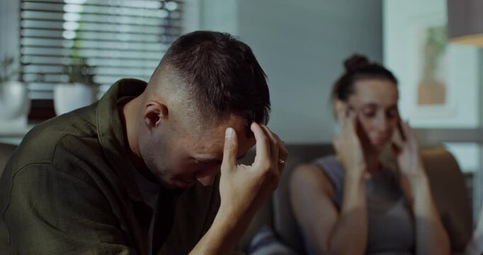 A family quarrel. A man and a woman are fighting while sitting on the couch, they look offended