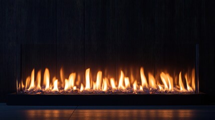 Fototapeta premium Dancing Flames Illuminating a Dark Setting with a Modern Glass Barrier and Smooth Stone Base