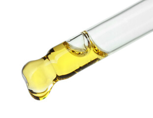 Dripping essential oil from pipette on white background