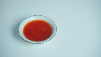 Sweet chili sauce in a white ceramic bowl isolated on white.