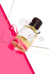 A perfume bottle with water droplets on a pink and white background. Perfect for beauty, fragrance,