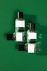 A minimalist and modern image featuring four perfume bottles on a green background.