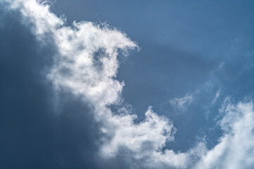 Fototapeta premium Dramatic cloudscape with fluffy cumulus clouds against a vibrant blue sky. This versatile image evokes feelings of freedom, peace, and possibility. 