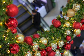 New Year decorations and a simulated Christmas tree in a shopping mall with people in the background.