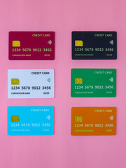 Colorful mock-up of six credit cards in various colors on a pink background