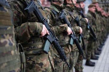 Polish army soldiers holding rifles on their bellies during roll call