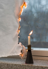 The candle has set the curtains on fire.