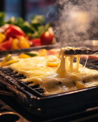 Swiss raclette with melted cheese dripping over potatoes