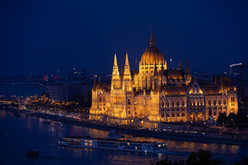 Obraz premium Hungarian Parliament building during blue hour. Night landscape in Budapest with the historical landmark building of the parliament next to Danube river.