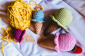 Atelier de crochet avec des travaux en cours, jouet petits cornets de glace colorés en crochet © PicsArt
