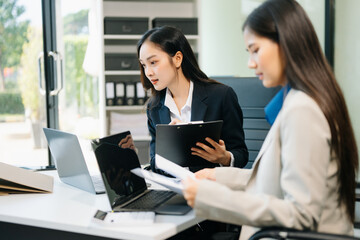 Obraz premium Businesswomen work and discuss their business plans. A woman employee explains