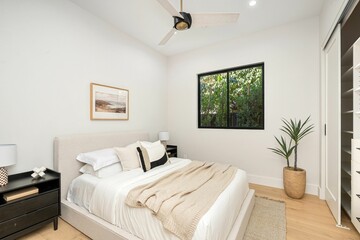 Modern bedroom with neutral decor and natural light.