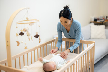 Mom helping to change her baby diaper