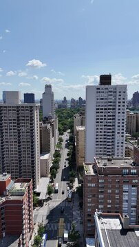 A dynamic vertical orientation drone push-in shot of W 95th Street in New York City, capturing the vibrant Manhattan streets, towering skyscrapers, and urban energy.