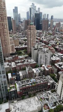 A captivating vertical orientation aerial drone shot over W 52nd Street in New York City, showcasing Manhattan&rsquo;s vibrant cityscape, towering skyscrapers, and bustling streets.