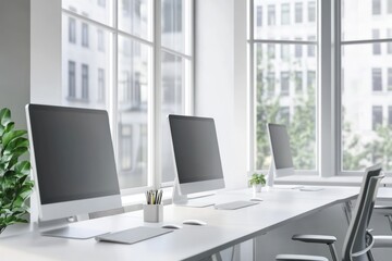 Modern office with computer monitors on desks near large windows, bright workspace