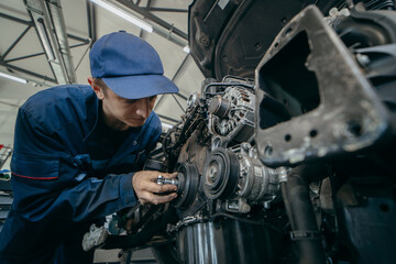 Auto mechanic repairs an engine. Replacing the timing chain